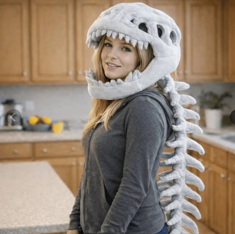 Adult wearing plush dino skeleton head hat with spine tail