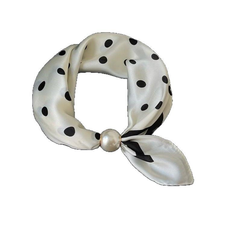 White polka dot neckerchief looped and closed with the pearl clasp