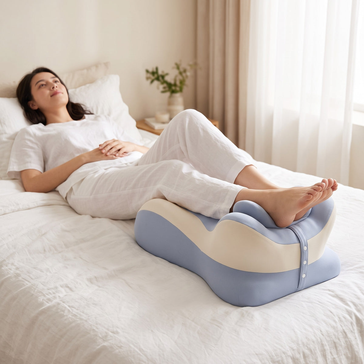 Legs elevated on the CozyCurve pillow in bed, blue and cream