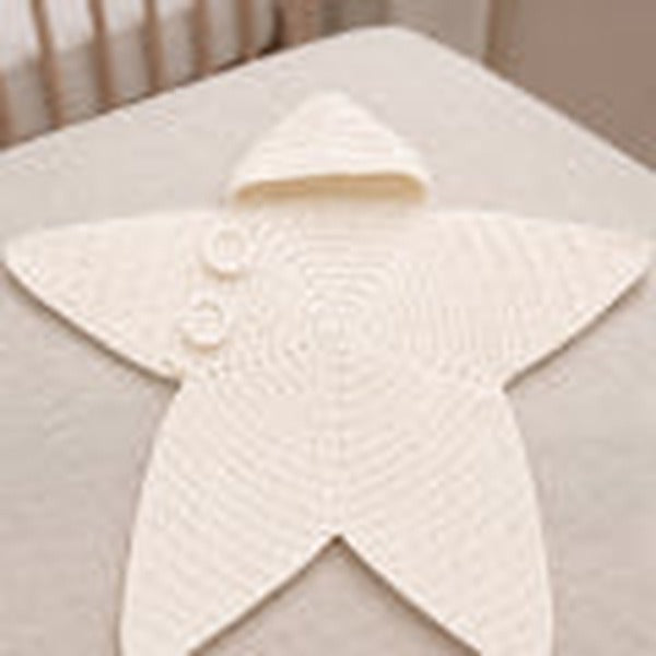Hand-crocheted star-shaped baby bunting sleeping bag with hood on a newborn