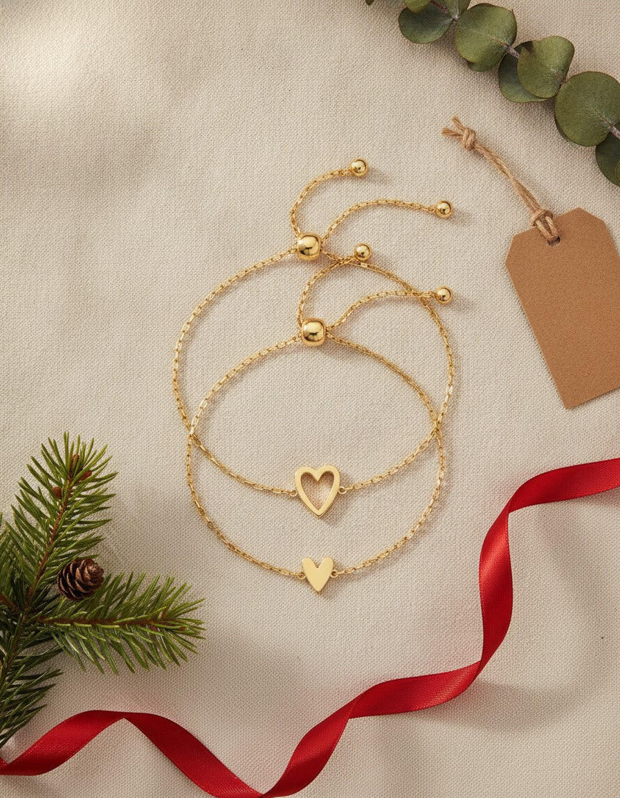 Gold matching hearts bracelet set on linen with pine and red ribbon