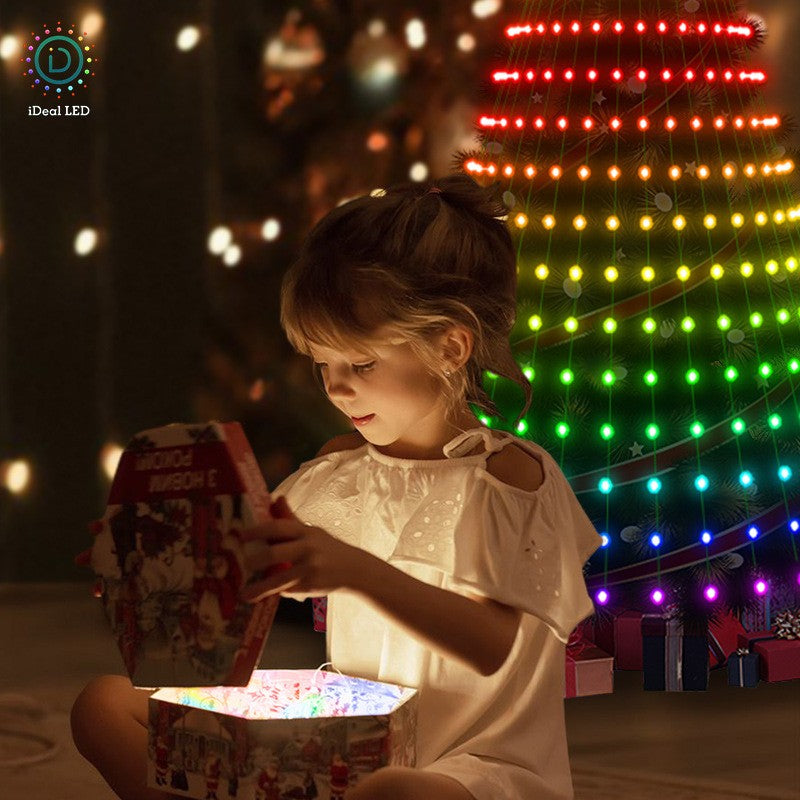 Girl opening a glowing gift box in front of rainbow Christmas tree lights