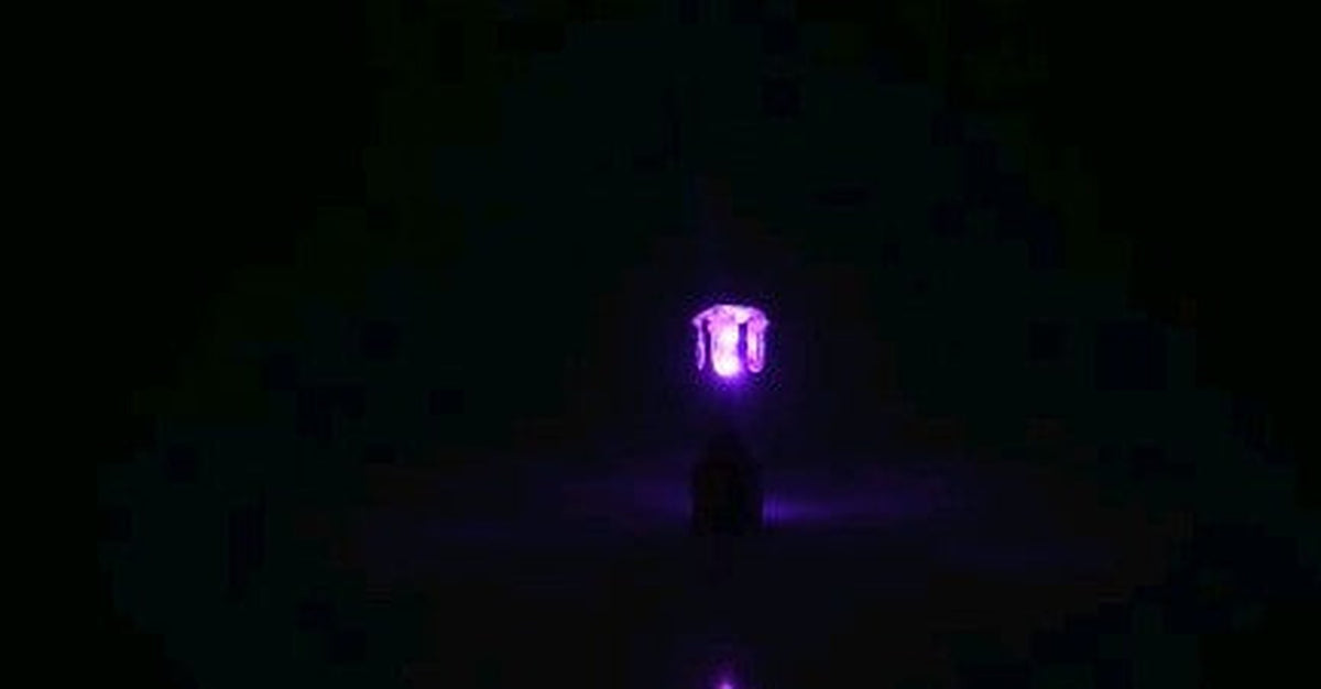 Pink LED stud earring glowing in the dark