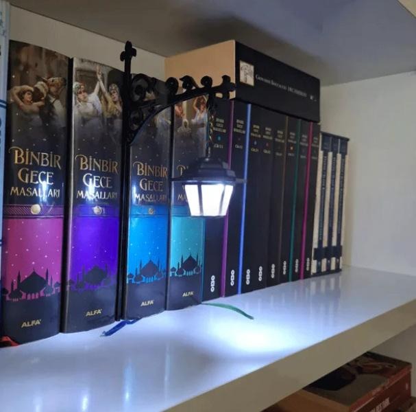 Lantern bookshelf insert between colorful books