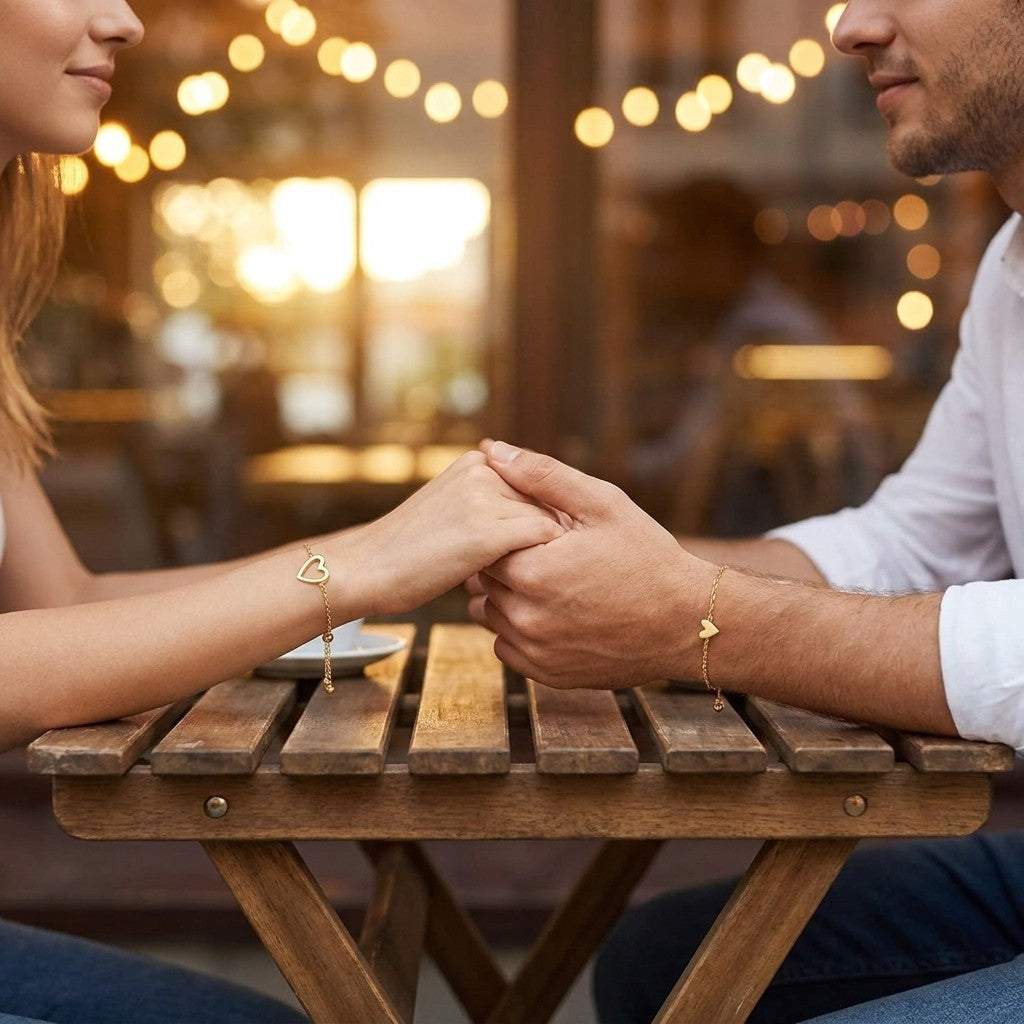 Couple holding hands wearing the gold open-heart and solid-heart bracelets