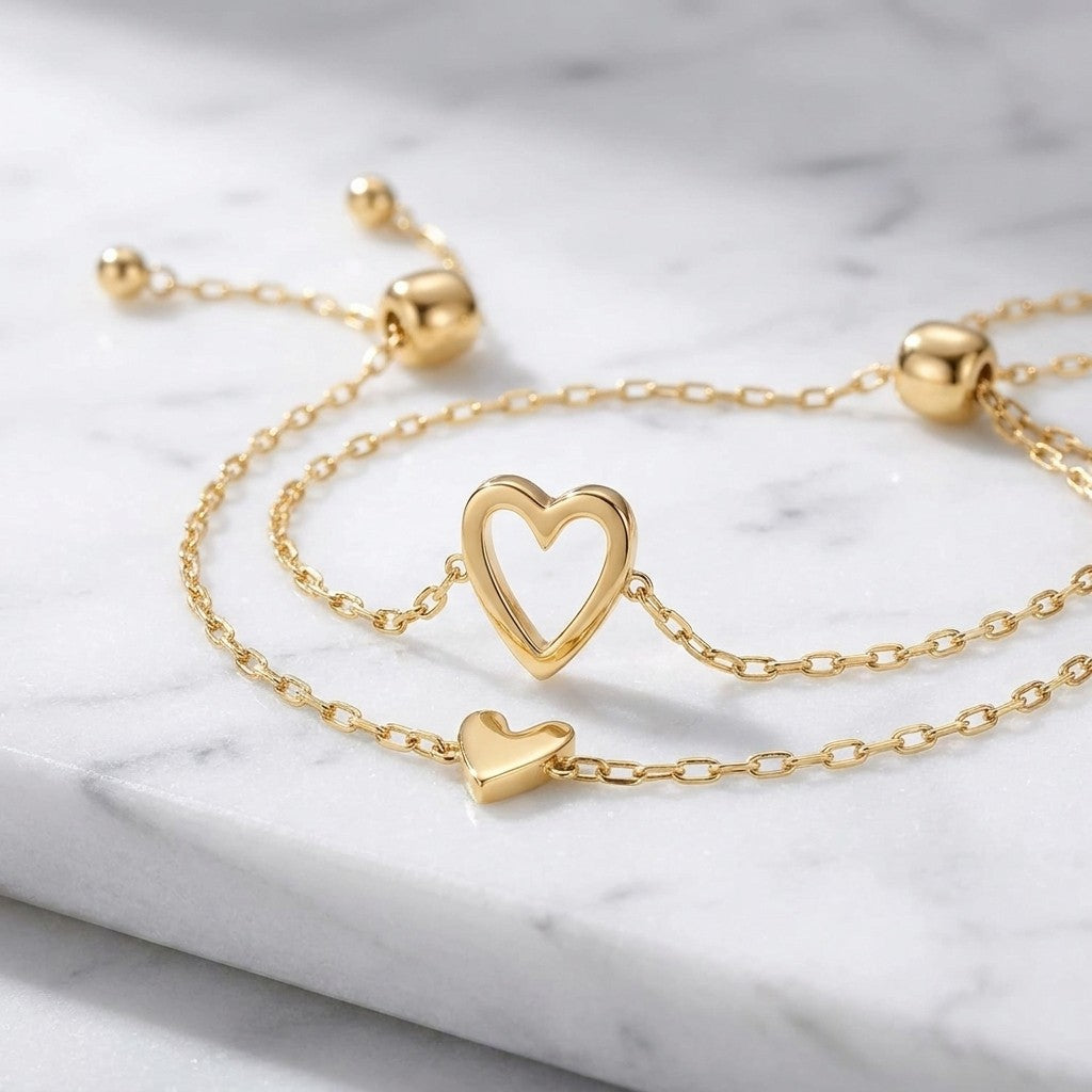 Close-up of the gold open heart and solid heart charms on marble