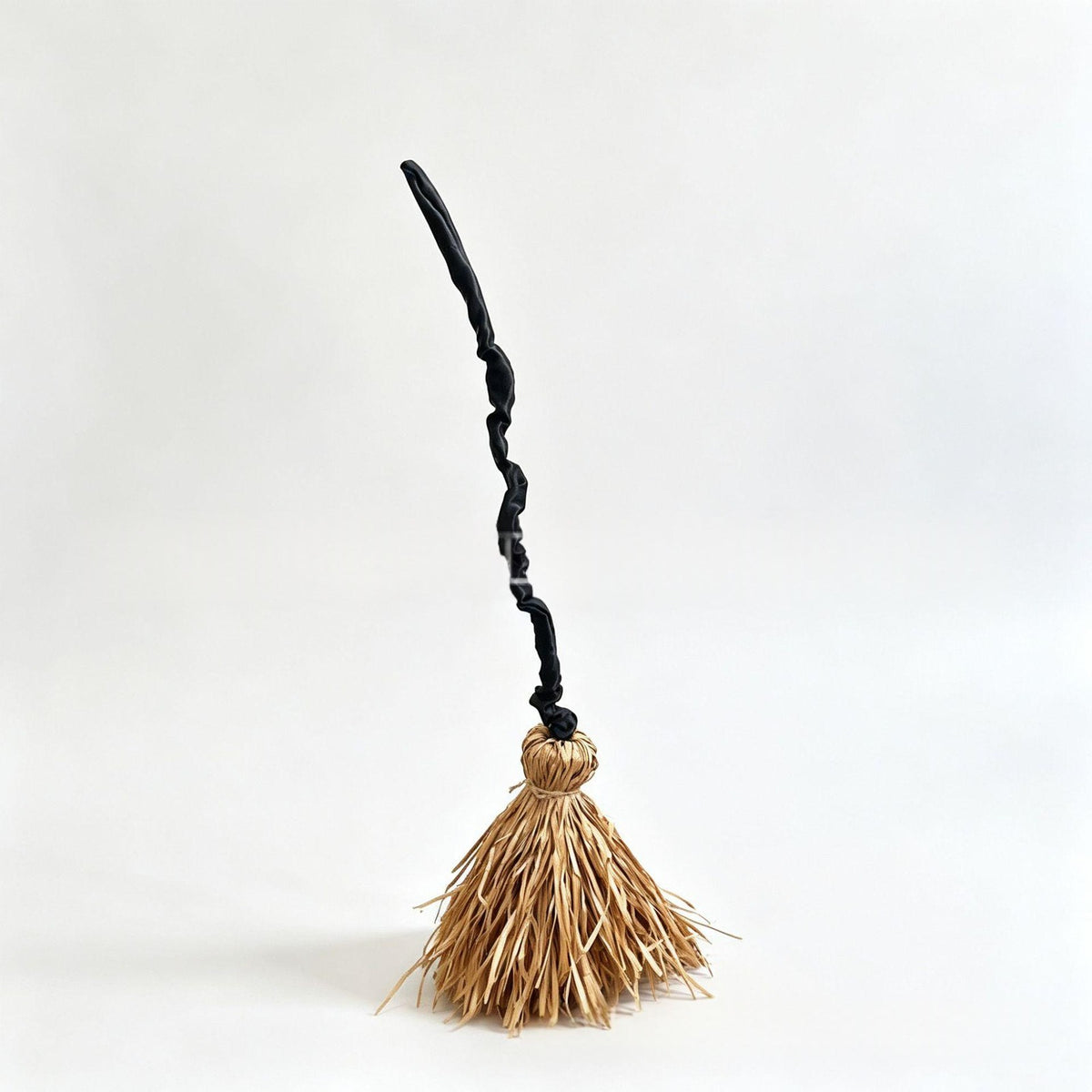 Witch broom with straw bristles and twisted black handle